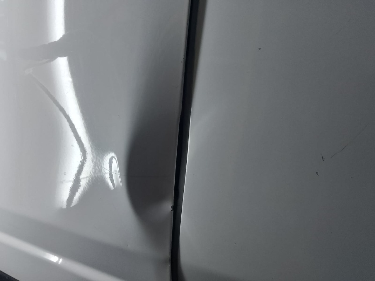 Amassado identificado na lataria com reflexo de luz